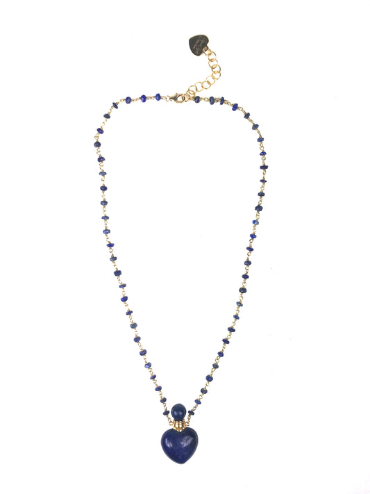 The Gena Myint Lapis Lazuli Heart Necklace features a blue beaded design with a heart-shaped pendant and gold chain clasp.