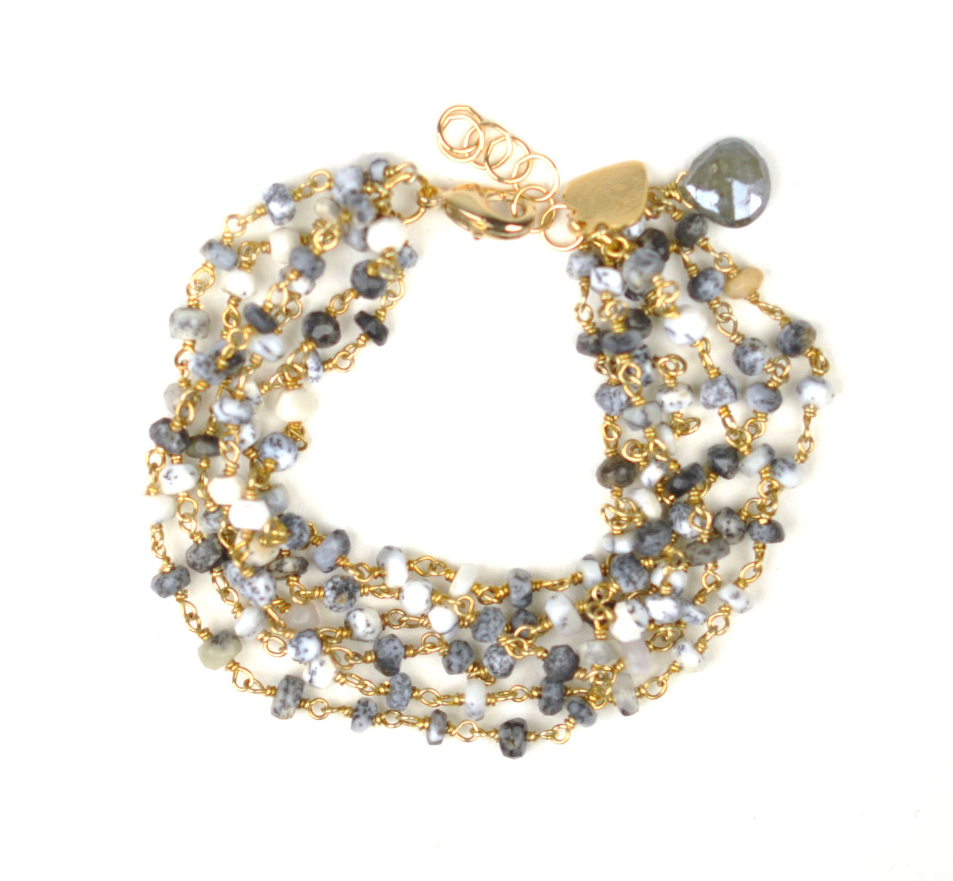 The Dalmatian Opal Bracelet by Gena Myint is a stylish multi-strand accessory with small gray and white beads linked by gold chains, complemented with a gold clasp and heart charm.