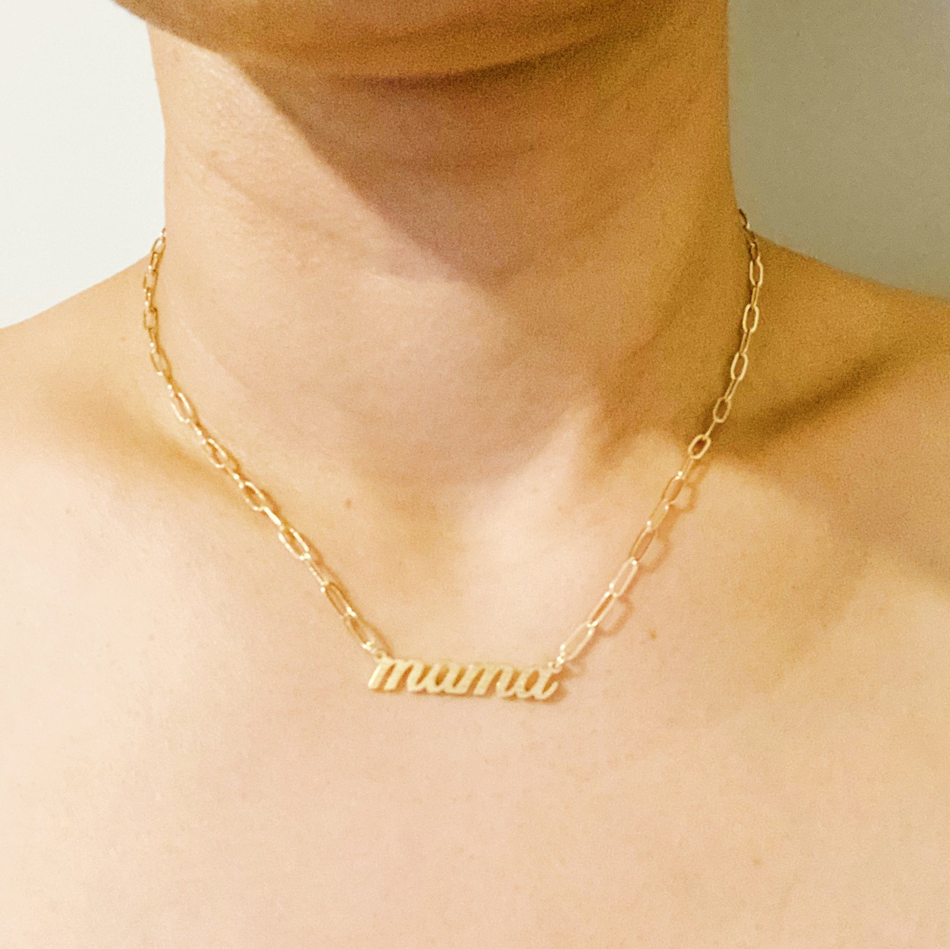 The Mama Link Chain Necklace by Ellison + Young features a gold chain with mama in cursive at the center.