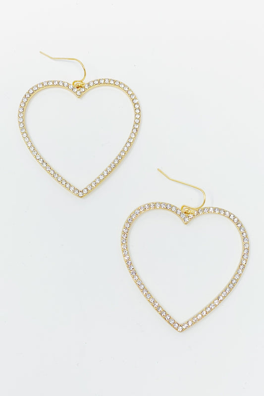 The My Precious Heart Earrings by Ellison + Young feature two gold heart-shaped designs adorned with rhinestones, shown on a white background.