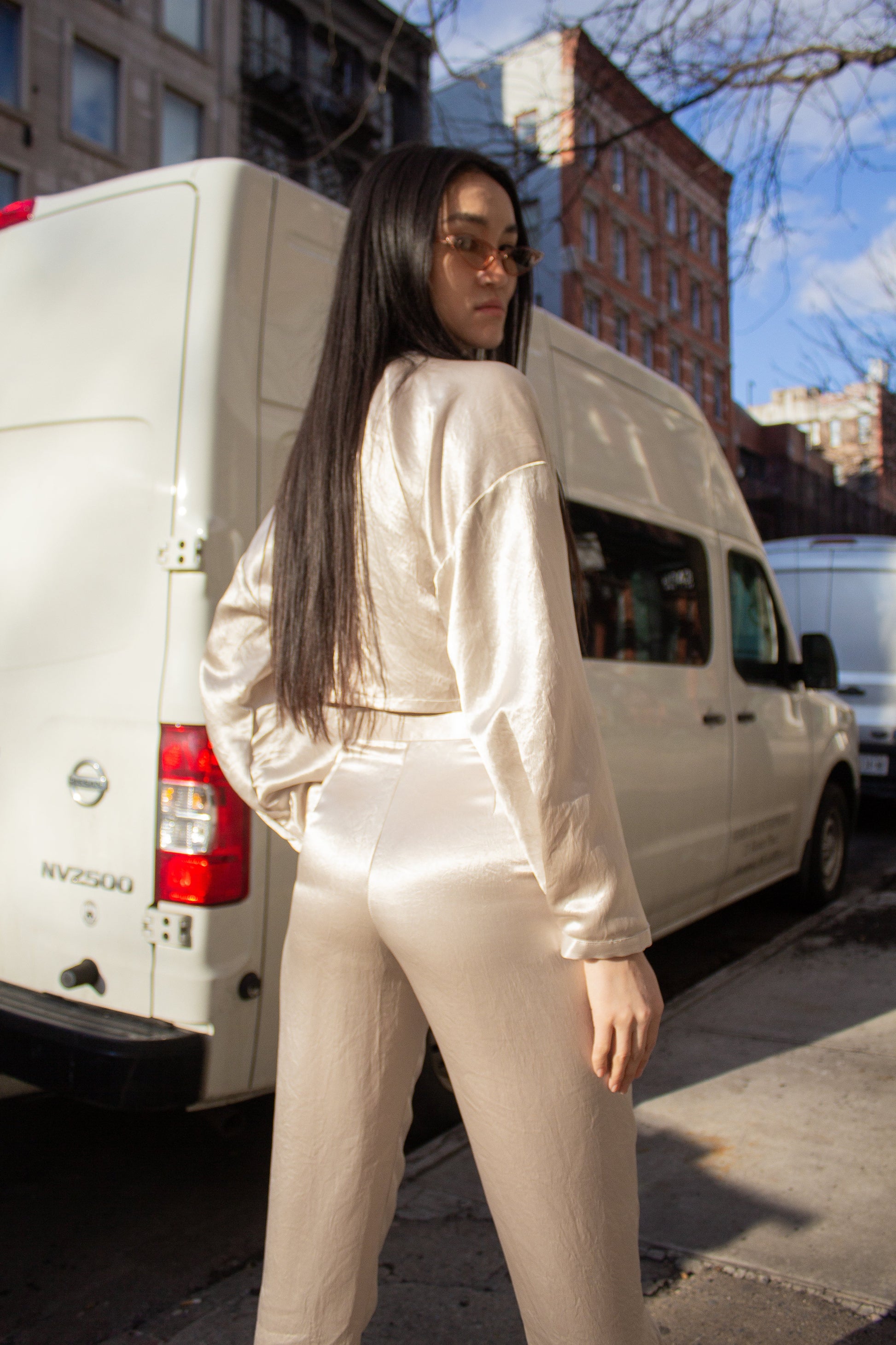 Sophie Beige Pants by Le Réussi®: Silk satin high-waisted trousers in light cream, shown from the back.