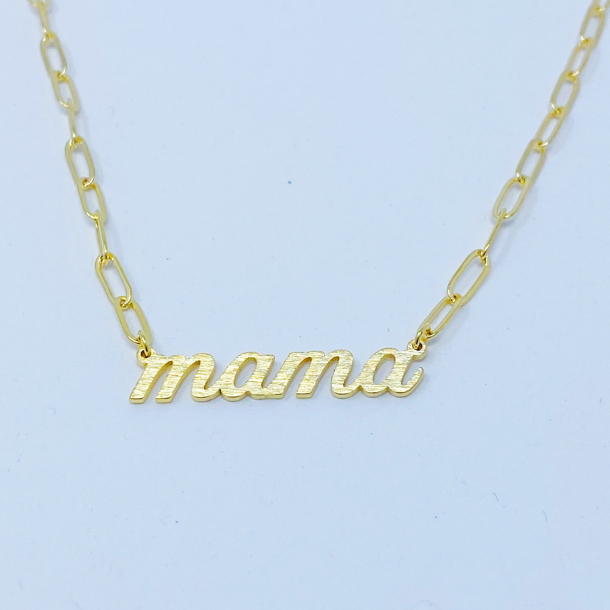 The Mama Link Chain Necklace by Ellison + Young features a gold chain with mama in cursive at the center.